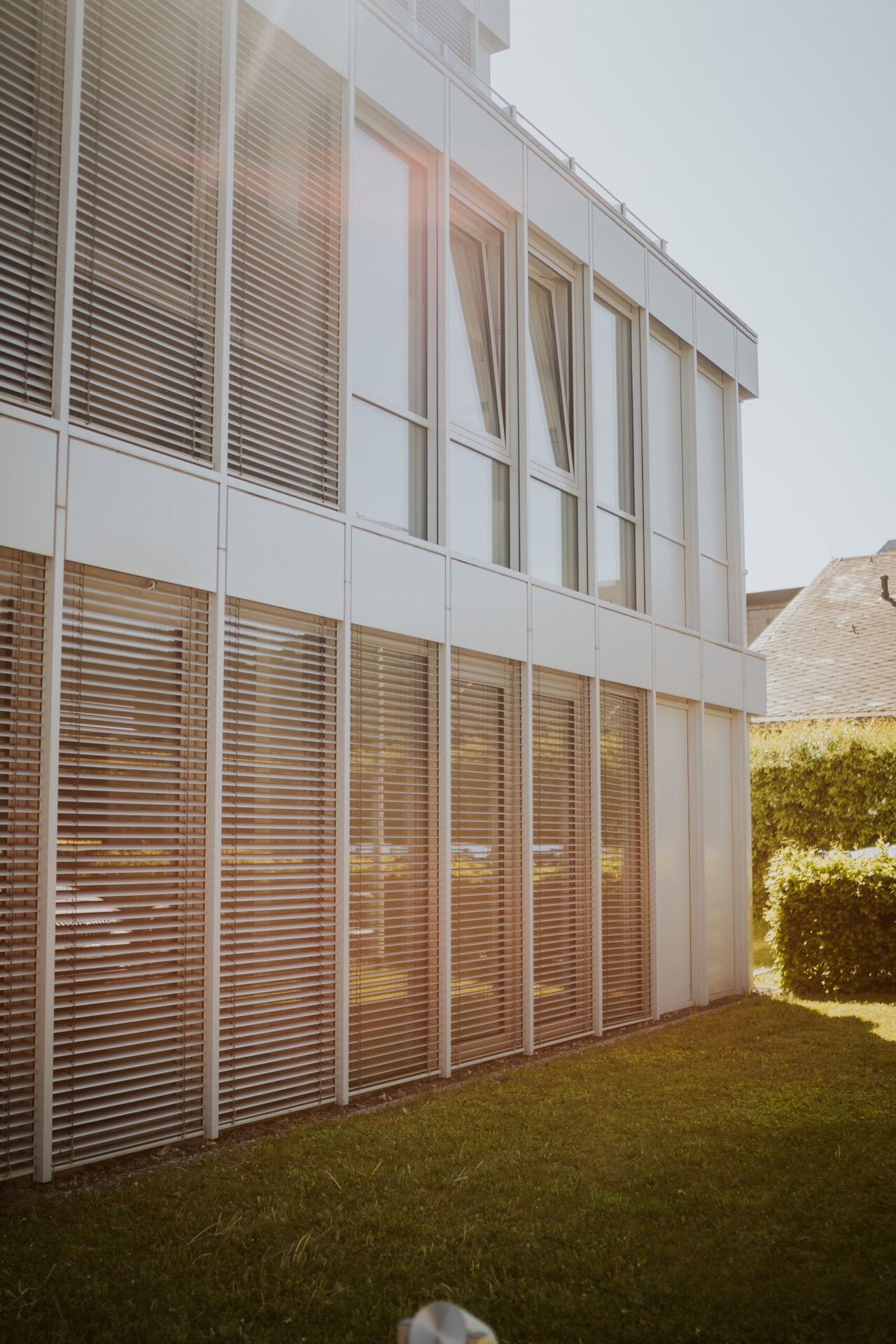 Modernes Gebäude mit Sonnenlicht, Fenster und Jalousien