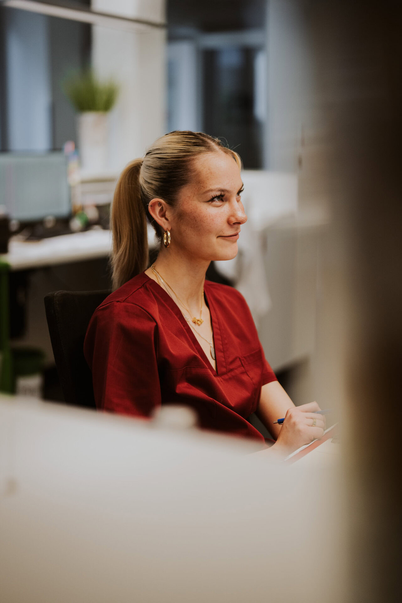 Eine Rezeptionistin ist an ihrem Schreibtisch zu sehen