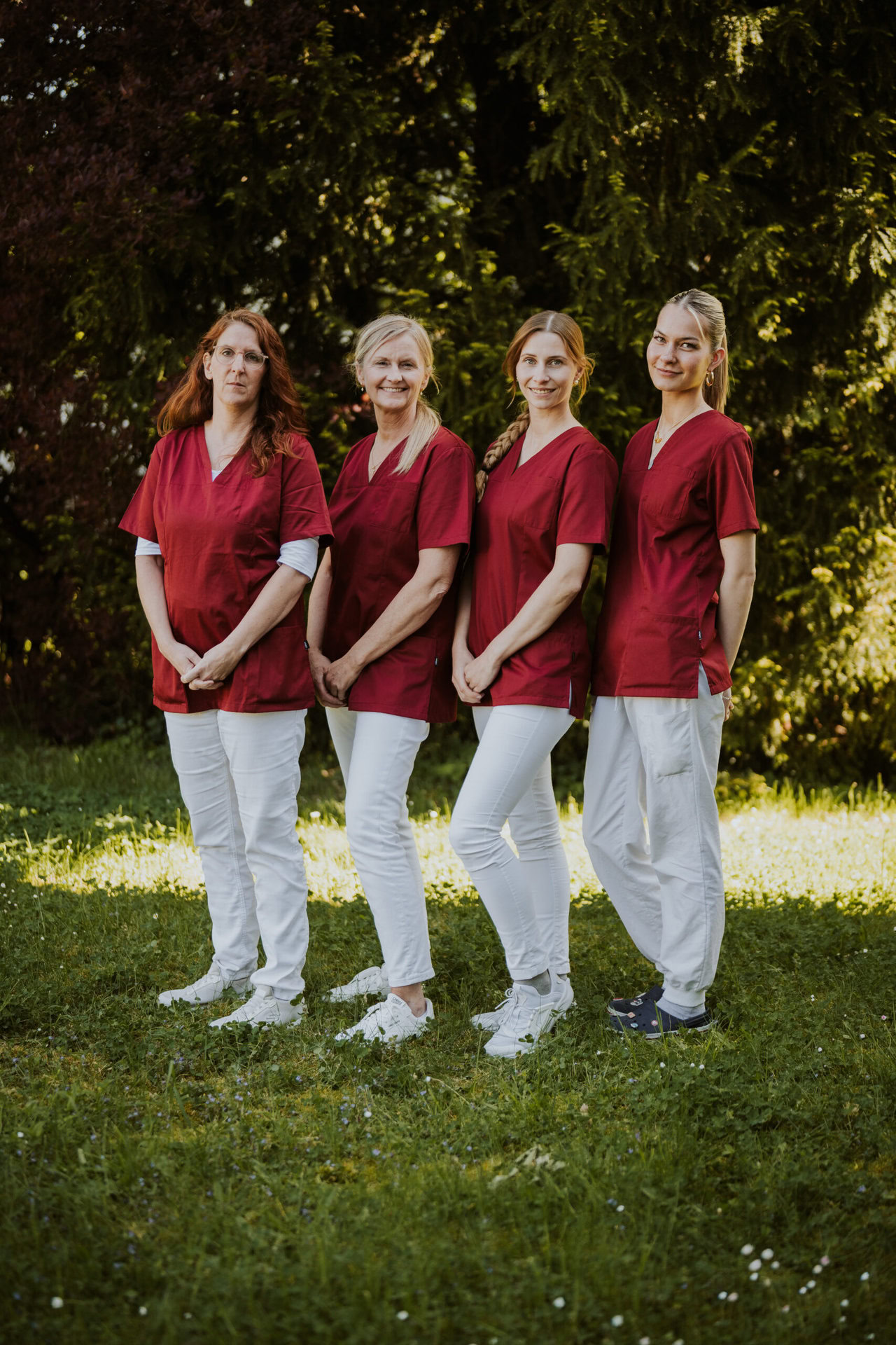 4 MFAs in roten Medizin-Uniformen vor Naturkulisse.