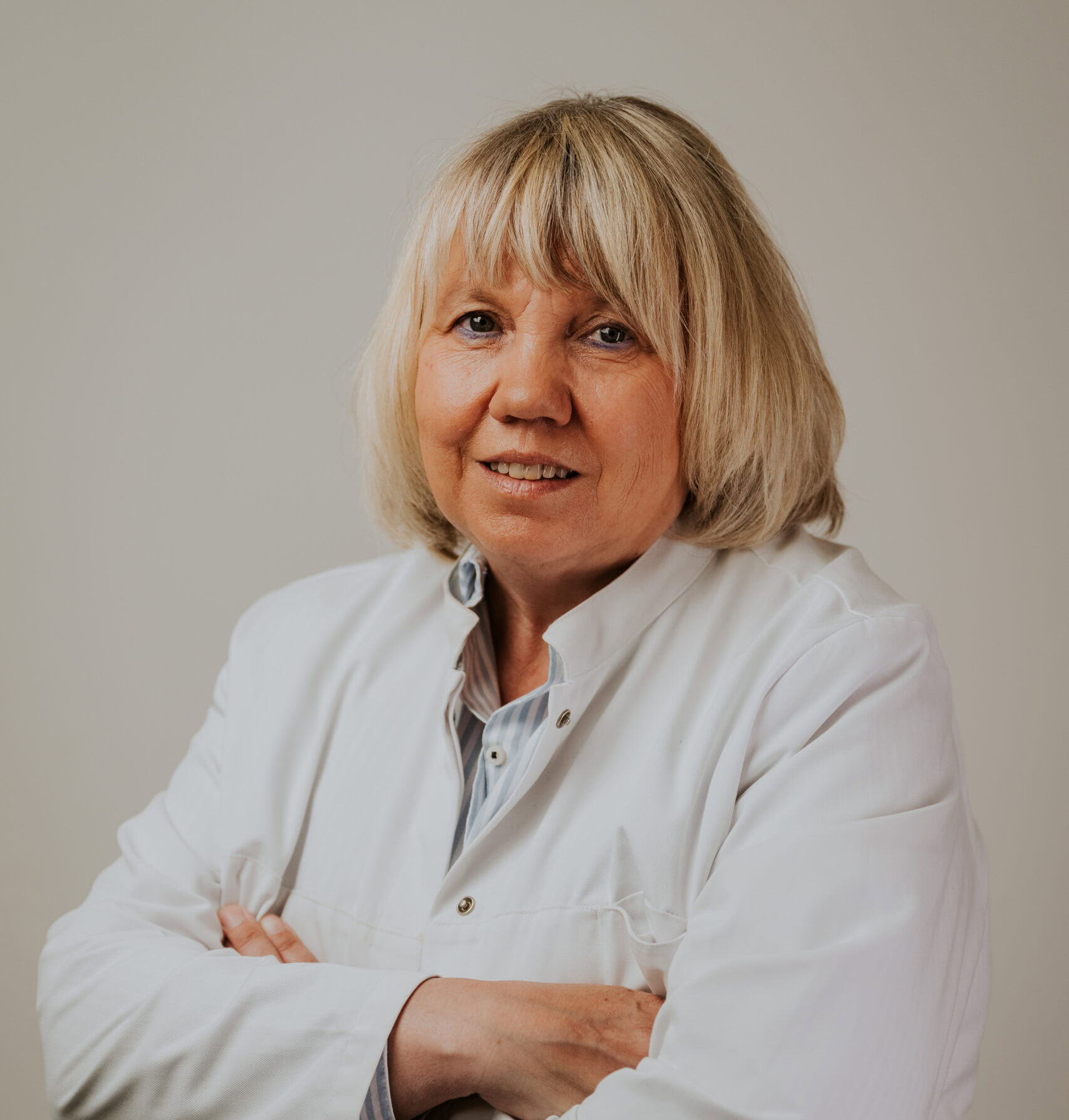 Frau Schmitz in weißem Kittel